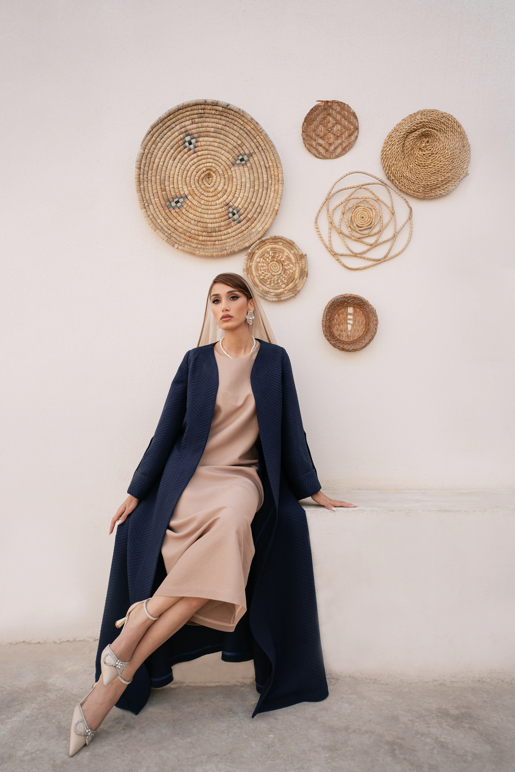 Woman in a navy wool coat over a sand dress