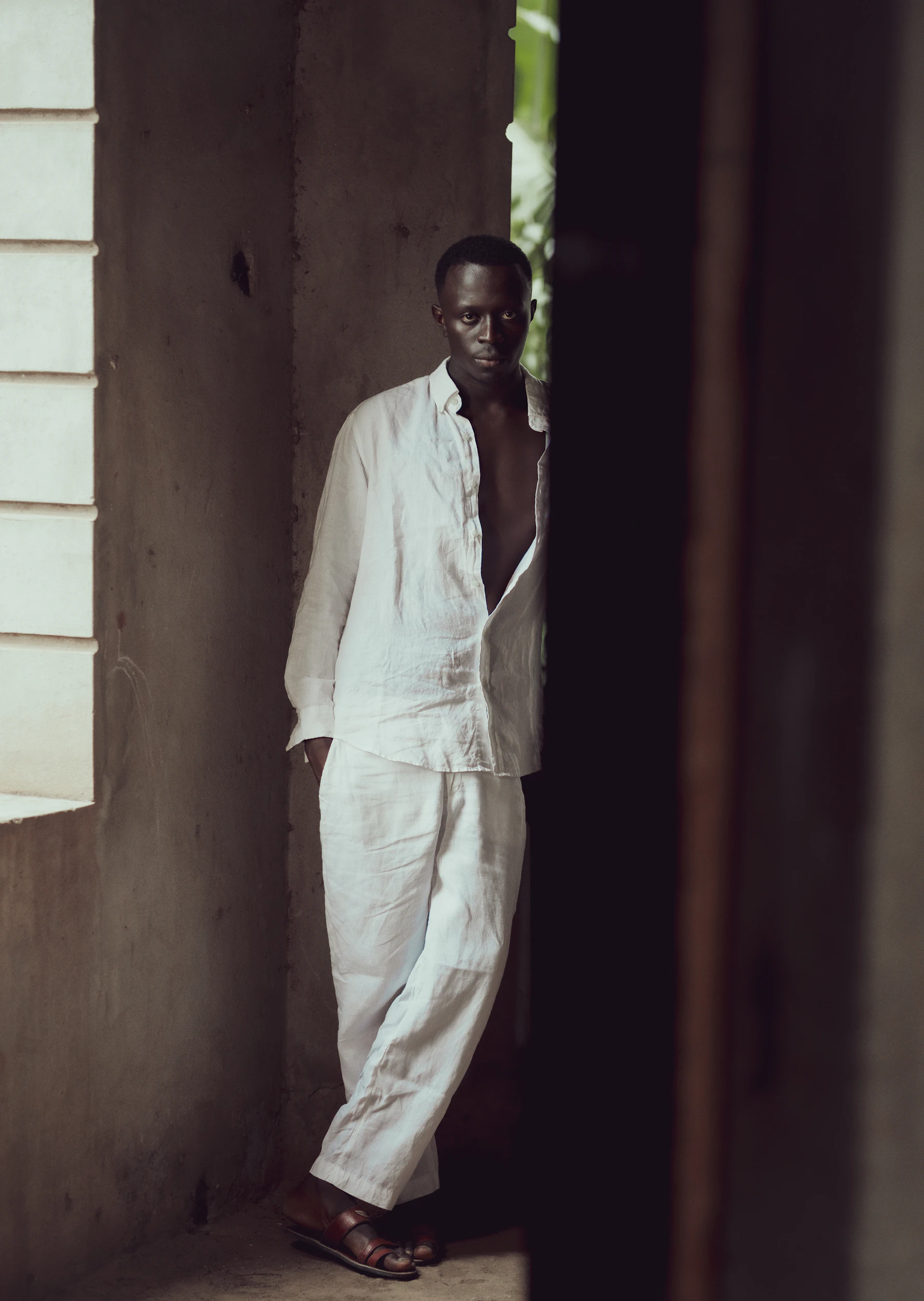Man in a linen shirt standing in a doorway