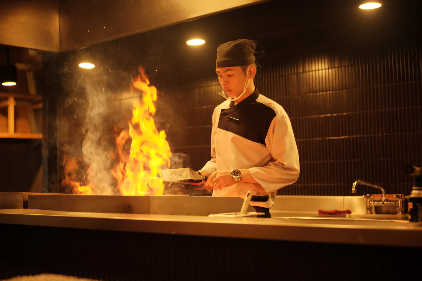 A cook working over an open flame