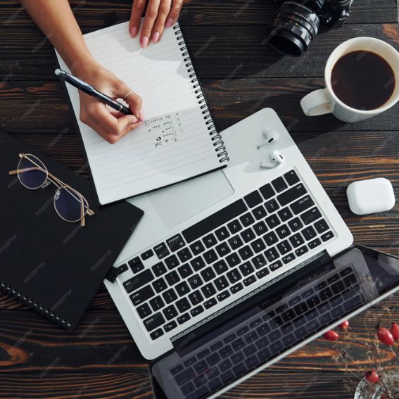 Notebook, laptop and coffee on a wooden desk