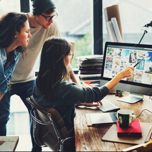 Team reviewing a project on a desktop computer