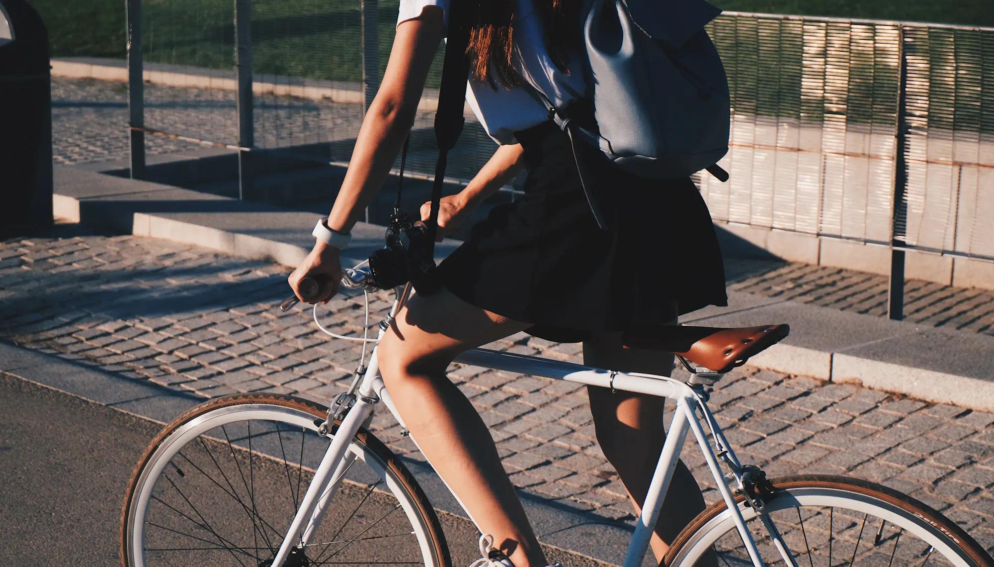 Close view of a rider on a white bicycle with a tan leather saddle