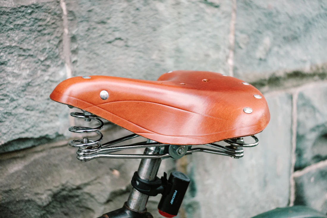 A tan leather saddle with steel springs