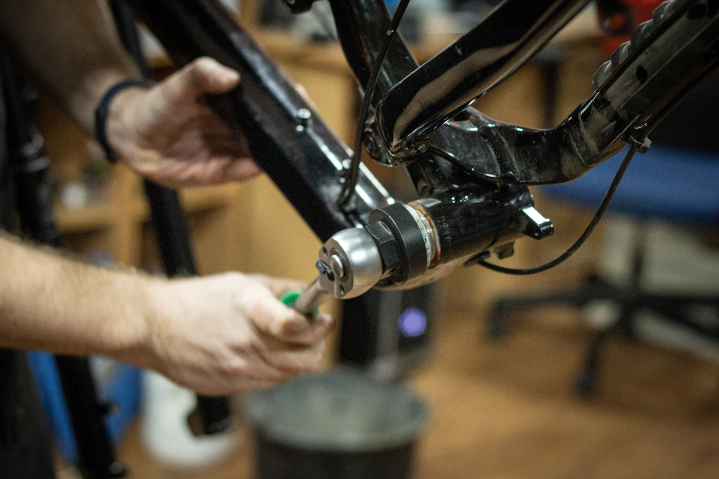 Hands fitting a bottom bracket into a bicycle frame