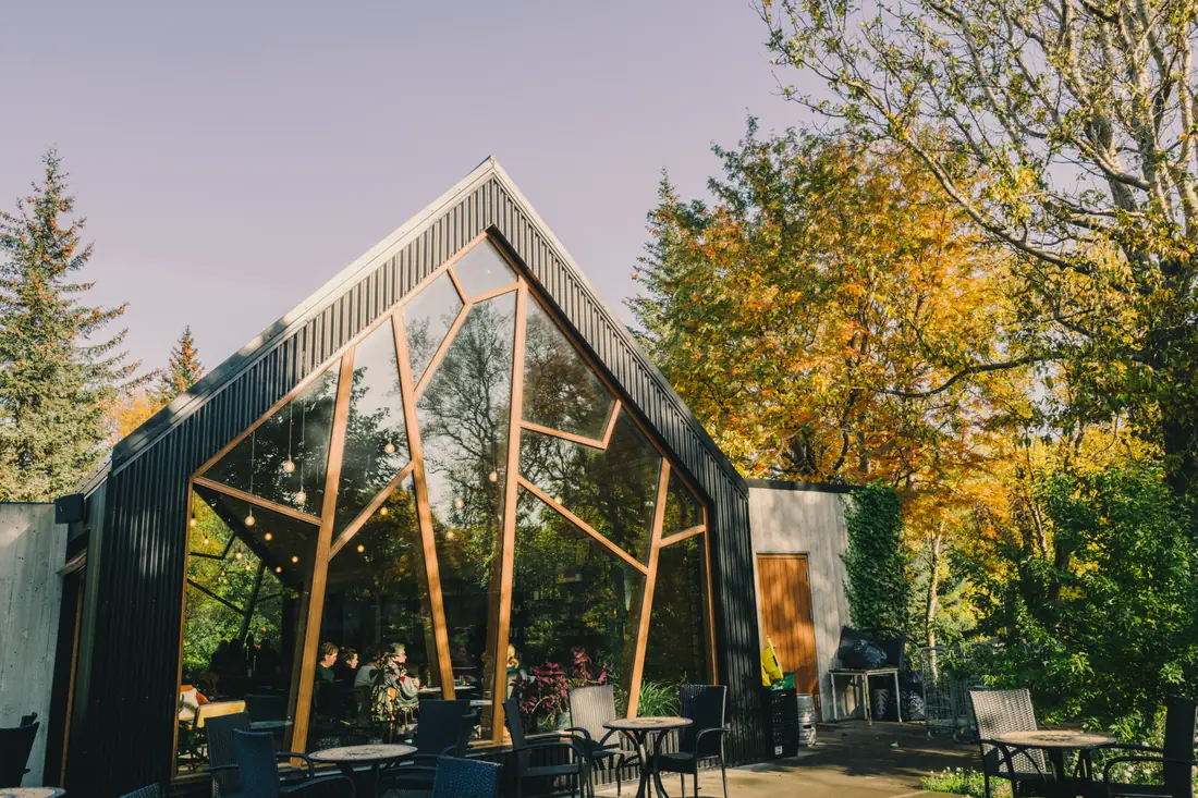 A glass and wood cafe among autumn trees