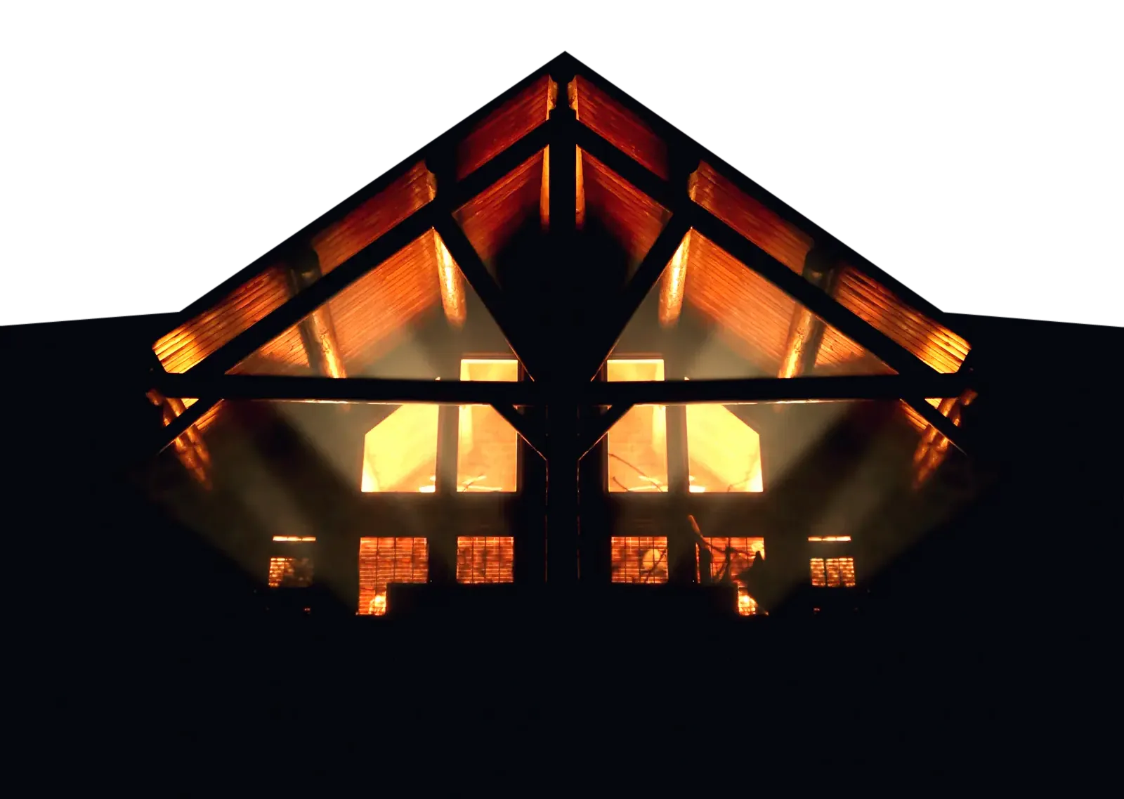 An A-frame cabin at night, its glass roof lit from inside
