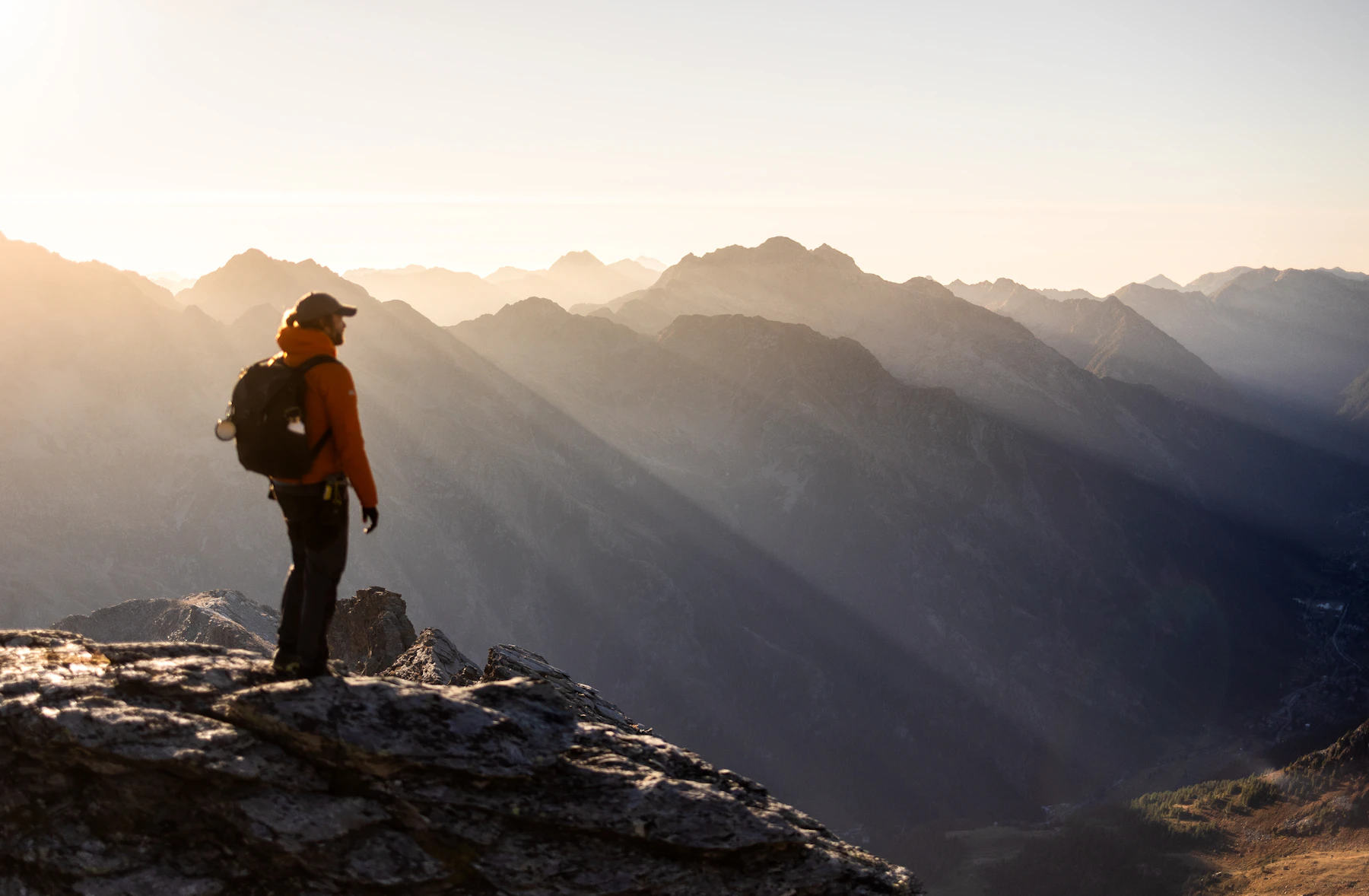 Hiker on a summit at sunrise with the Ridgeborn 65
