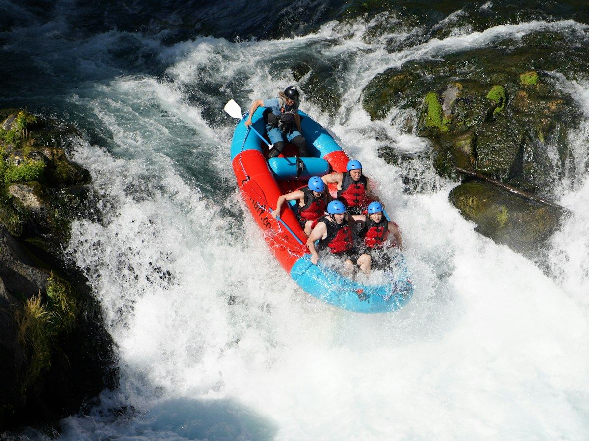 Raft dropping into a steep whitewater rapid